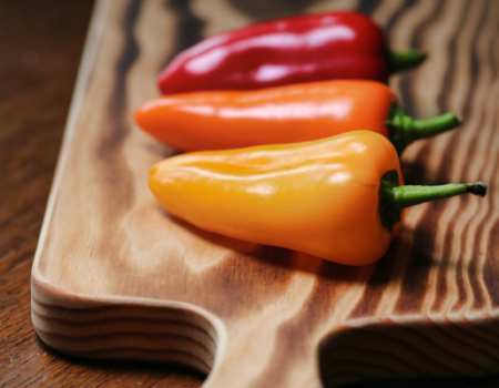 artica+i. Imagen para la galería interior del caso de éxito (nuestros proyectos) "NUTRIALITEC", mostrando una fotografía artística de unos pimientos de diferentes colores sobre una tabla de cortar