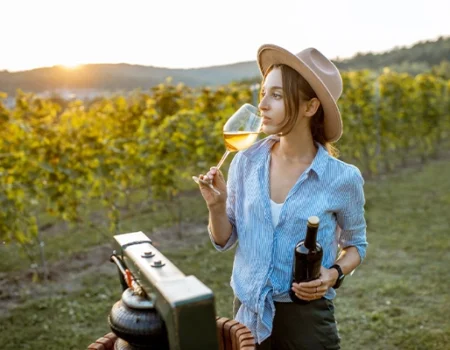 artica+i. Imagen para la galería interior del caso de éxito (nuestros proyectos) "POLYRESWINE. Proyecto de I+D orientado a aplicar nuevas técnicas basadas en resinas de intercambio iónico/absorbentes para eliminar compuestos indeseables en el vino", mostrando a una mujer degustando mosto en un viñedo