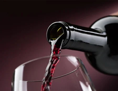 artica+i. Imagen para la galería interior del caso de éxito (nuestros proyectos) "POLYRESWINE. Proyecto de I+D orientado a aplicar nuevas técnicas basadas en resinas de intercambio iónico/absorbentes para eliminar compuestos indeseables en el vino", mostrando el detalle de una botella vertiendo vino en una copa