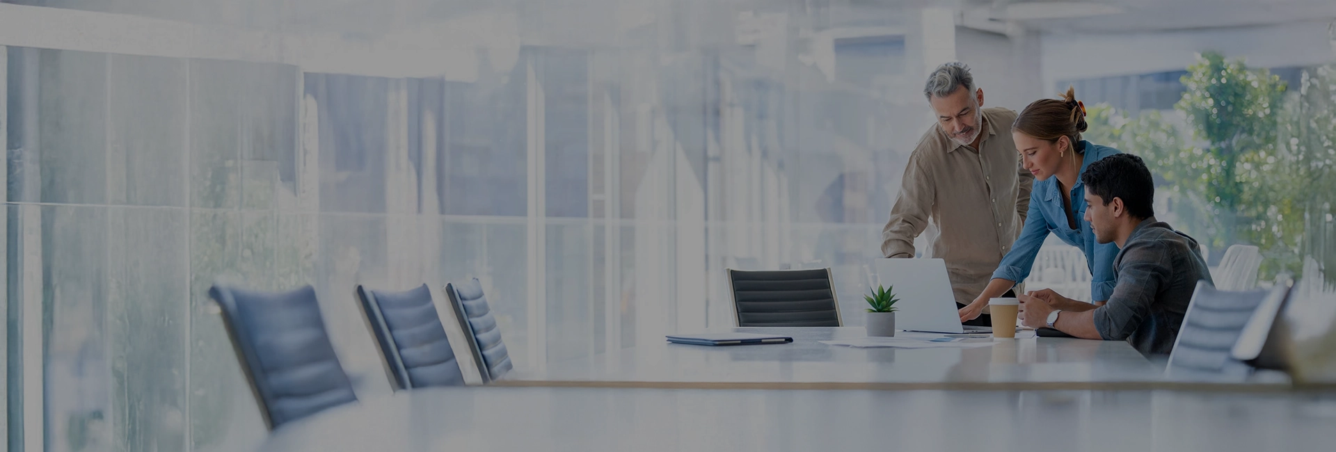 artica+i. Imagen de cabecera general para los posts de blog de la sección de actualidad de la web llamada "iMagazine" mostrando a tres personas sentadas en una mesa de oficina moderna frene a un portátil