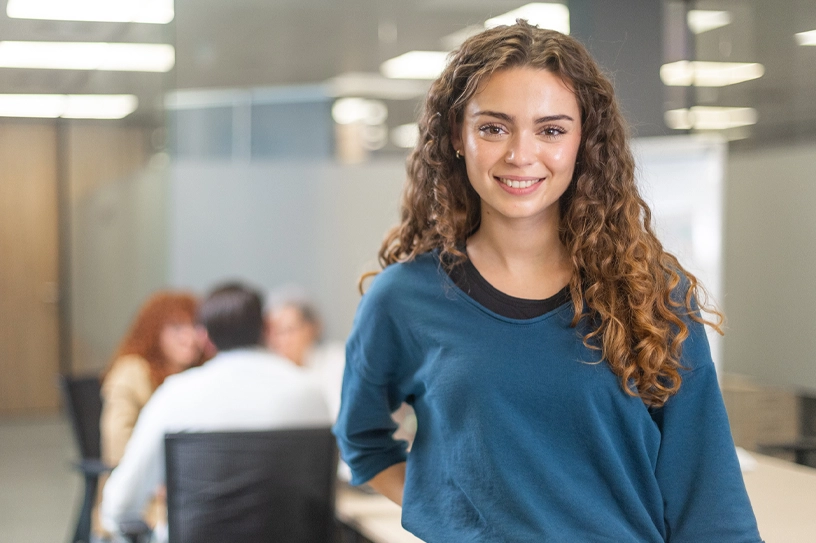 Artica+i, Casos de Éxito. Imagen de listado para el proyecto vinculado a artica+i: TALENTO JOVEN, mostrando a una chica joven en unas oficinas modernas.